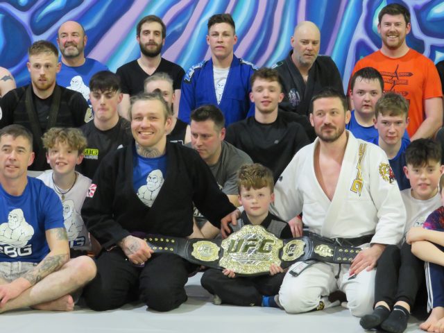 Philip Mulpeter and John Kavanagh with Conor McGregor's UFC belt