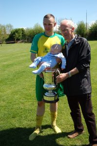 Lee Salter with his grandfather and son, holding the premier cup.