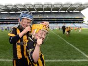 LJ Cuddy, left, helps team-mate Tadgh Lowry with his helmet, representing Camross at the Go Games in Croke Park