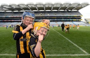 LJ Cuddy, left, helps team-mate Tadgh Lowry with his helmet, representing Camross at the Go Games in Croke Park