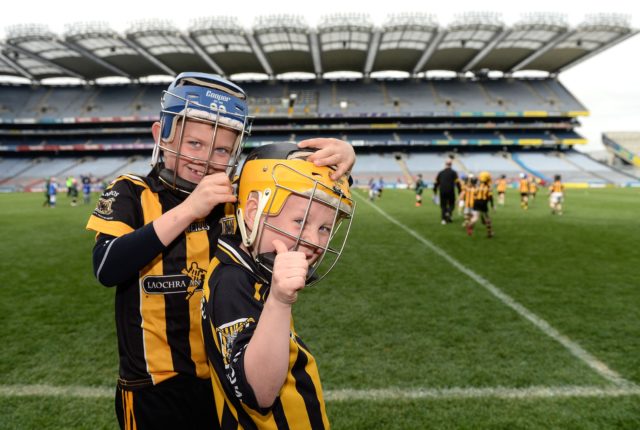 LJ Cuddy, left, helps team-mate Tadgh Lowry with his helmet, representing Camross at the Go Games in Croke Park