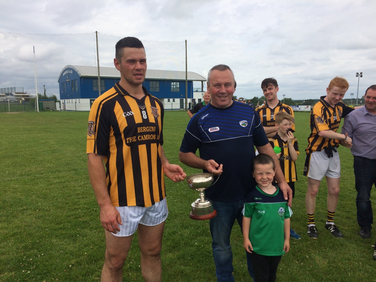 Camross captain Andrew Collier receiving the cup from Seamus Mortimer
