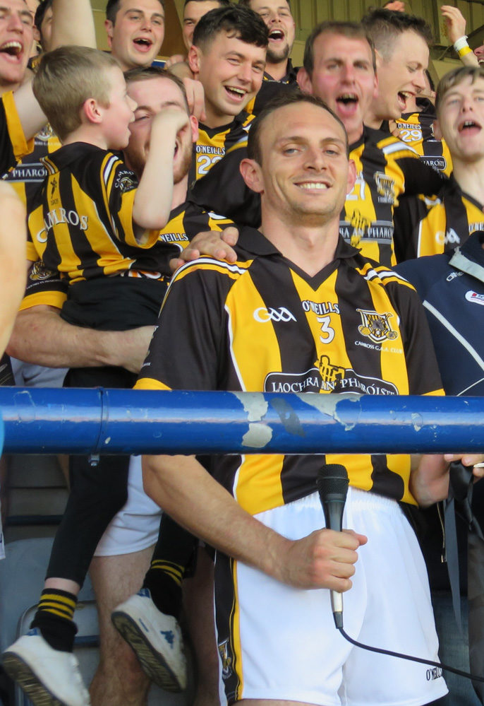 Joe Phelan and Zane Keenan receive the Bob O'Keeffe Cup from Seamus Mortimer