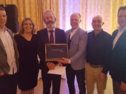 Stephen Attride, Sinead Delaney, Brian Stapleton, John Maye and Chris Conway present John Behan, centre, with a book of photos and memories from his time in Knockbeg