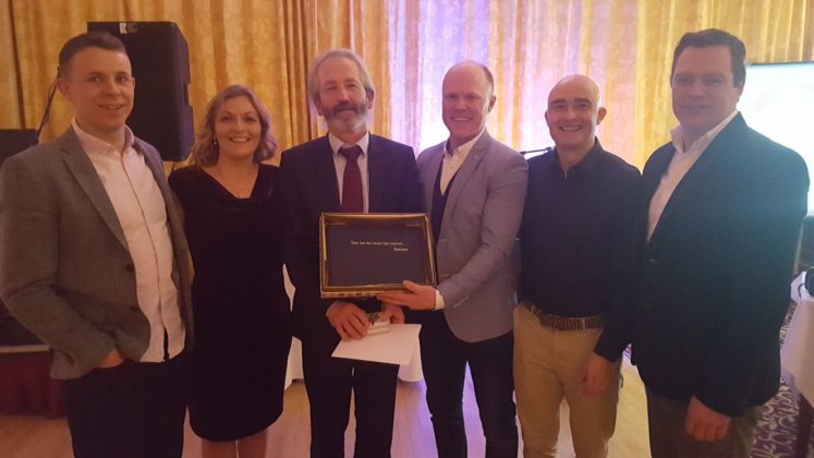 Stephen Attride, Sinead Delaney, Brian Stapleton, John Maye and Chris Conway present John Behan, centre, with a book of photos and memories from his time in Knockbeg