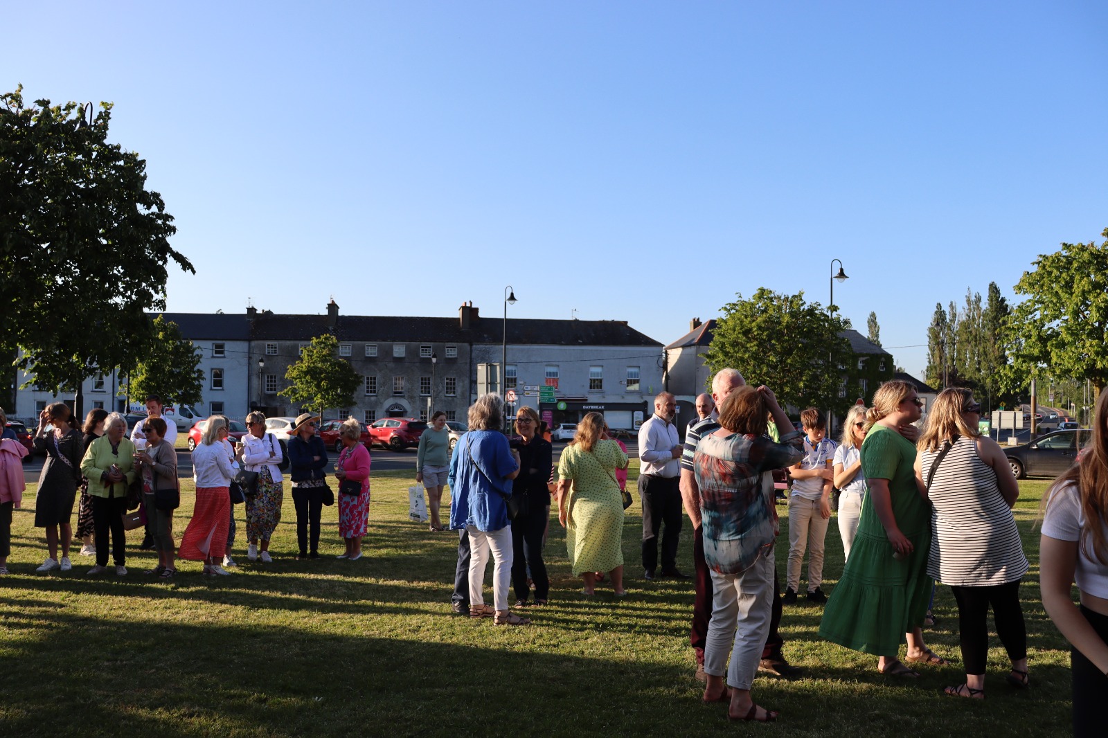 the crowd enjoying the evening sun and style at the Fifty-Seven event